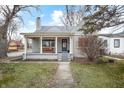 Charming bungalow featuring a covered front porch with a cozy bench and well-manicured landscaping at 5240 E 10Th St, Indianapolis, IN 46219