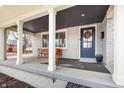 Welcoming front porch with a seating bench, decorative wreath, and a classic blue front door at 5240 E 10Th St, Indianapolis, IN 46219