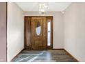 Inviting foyer with wood floors, a decorative front door with glass panels, and a modern light fixture at 5272 N Graham Rd, Whiteland, IN 46184