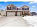 Two-story brick and siding home with a three car garage and a large concrete driveway at 6281 Burgin Dr, Whitestown, IN 46075
