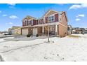 Two-story home with brick accents, three-car garage, and a snow-covered front yard at 6281 Burgin Dr, Whitestown, IN 46075