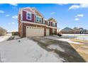 Two-story home with brick accents, three-car garage, and a snow-covered front yard at 6281 Burgin Dr, Whitestown, IN 46075