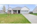 Single-Gathering home with manicured lawn, stone accents, covered porch, and a two-car garage at 6848 Kara Ln, Brownsburg, IN 46112
