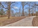 Well-maintained gray home with a newly paved driveway and mature trees at 7999 Englewood Rd, Indianapolis, IN 46240