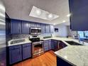 Modern kitchen with stainless steel appliances, granite countertops, and stylish blue cabinetry at 8150 Foxchase Cir, Indianapolis, IN 46256