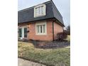 Brick townhouse exterior featuring dormer window and landscaped yard at 8501 Canterbury E Sq, Indianapolis, IN 46260