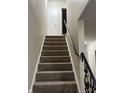 Carpeted staircase with white walls and black railing in a residential home at 8501 Canterbury E Sq, Indianapolis, IN 46260