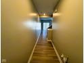 View of a long hallway with wood floors leading to a staircase and back doorway with ample natural light at 9634 Beckett St, Avon, IN 46123
