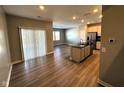 Open concept view of the kitchen, dining, and living area with stainless steel appliances and wood flooring at 9634 Beckett St, Avon, IN 46123