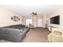 Open living room boasts a large sectional sofa, a ceiling fan, and ample natural light at 1058 W Limestone Way, Fortville, IN 46040