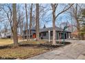 Charming gray home exterior with an open driveway, a basketball hoop, and tasteful landscaping at 11035 W Lakeshore Dr, Carmel, IN 46033