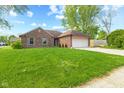 Beautiful single-story brick home with a green lawn and mature trees at 1135 Sherwood Dr, Danville, IN 46122