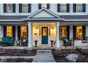 Inviting front porch with seating area, columns, and a charming teal-colored front door at 13139 Dumbarton St, Carmel, IN 46032
