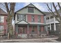 Charming red brick two-story home with a welcoming front porch and professionally landscaped front yard at 235 E 11Th St, Indianapolis, IN 46202