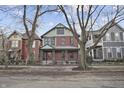 Charming red brick two-story home with a welcoming front porch and professionally landscaped front yard at 235 E 11Th St, Indianapolis, IN 46202