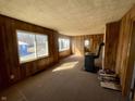 Cozy living room with wood paneling, a unique wood-burning stove, and lots of natural light at 256 Ringwood Way, Anderson, IN 46013