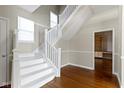 Bright foyer featuring hardwood floors and a staircase with white banisters and a large window at 2605 Carrollton Ave, Indianapolis, IN 46205