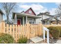 Inviting curb appeal with a red front door, covered porch, and a freshly installed wooden fence surrounding the property at 2914 N Delaware N St, Indianapolis, IN 46205