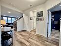 Bright hallway featuring wood floors, access to the living room, and stairs leading to the second floor at 4114 Spirea Dr, Plainfield, IN 46168