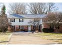 Traditional two-story home with brick and siding exterior, enhanced by a neat lawn and mature trees at 523 Memory Ln, Carmel, IN 46032