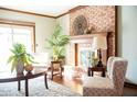 Bright living area features a brick fireplace, wood floors, and a sliding door to the outside at 523 Memory Ln, Carmel, IN 46032