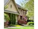 Charming brick home featuring manicured landscaping, an American flag, and unique architectural details at 6045 Channel Dr, Columbus, IN 47201