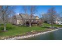 Stunning lakefront home with a screened porch, balcony, and a meticulously landscaped yard extending to the water's edge at 6045 Channel Dr, Columbus, IN 47201