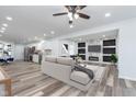 Open living room shows a sleek ceiling fan, hardwood floors, modern fireplace and television focal point at 650 S Lyons Ave, Indianapolis, IN 46241