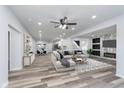 Open-concept living room featuring wood floors, recessed lighting, and an accent wall with fireplace and television at 650 S Lyons Ave, Indianapolis, IN 46241