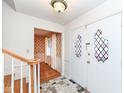 Foyer with decorative front door, mosaic tile flooring, and view into the living room at 6838 Johnson Rd, Indianapolis, IN 46220