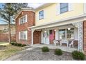 View of the front porch with decorative pillars, white iron benches, and an American flag at 6838 Johnson Rd, Indianapolis, IN 46220