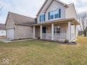 Beautiful home with a manicured lawn and a welcoming front porch with classic white railing at 7625 Corsican Cir, Avon, IN 46123