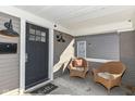 Charming front porch featuring stylish lighting, a welcoming doormat, and comfortable wicker chairs at 764 E 42Nd St, Indianapolis, IN 46205