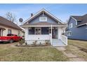 Charming blue two-story home featuring a welcoming front porch and landscaped yard at 832 N Parker Ave, Indianapolis, IN 46201