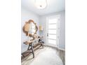 Inviting entryway features light gray walls, hardwood floors, stylish decor, and a white front door at 9748 Junction Station, Fishers, IN 46037