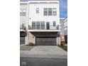 A modern townhome featuring a garage with a metal door and a small second story balcony at 9748 Junction Station, Fishers, IN 46037