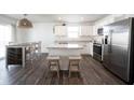 Bright, open kitchen featuring stainless steel appliances, white cabinets, and a center island with breakfast bar at 9858 Oakmont E Dr, Pendleton, IN 46064