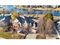 Aerial view of brick home with lake view, mature trees, and a well maintained driveway at 9970 Southwind Dr, Indianapolis, IN 46256