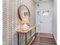 Inviting entryway featuring stylish wallpaper, wood floors, and a decorative mirror, creating a welcoming atmosphere at 1051 Macoun Dr, Westfield, IN 46074