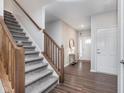 Inviting entryway featuring stylish wallpaper, wood floors, and a decorative mirror, complemented by a staircase at 1051 Macoun Dr, Westfield, IN 46074