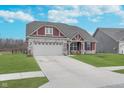 Charming home featuring a two-car garage, nicely manicured lawn, and stylish architectural details at 1051 Macoun Dr, Westfield, IN 46074