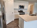 Modern kitchen with stainless steel appliances, white cabinets, quartz countertops, and a center island at 11305 N Quillow Way, Monrovia, IN 46157