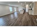 Spacious living room with hardwood floors and large windows, flowing into an open-concept kitchen with an island at 11305 N Quillow Way, Monrovia, IN 46157