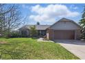 Charming ranch home featuring a brick facade, well-manicured lawn, and an attached two-car garage at 12205 Whitebark Dr, Indianapolis, IN 46236