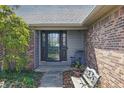 Inviting front entrance features a rocking chair and bench, surrounded by lush landscaping at 12205 Whitebark Dr, Indianapolis, IN 46236