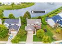 Aerial view of home and neighborhood with pond, mature trees, and lush green lawns at 12770 Bristow Ln, Fishers, IN 46037