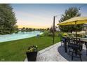Outdoor living space offers serene lake views, patio with table, and a meticulously kept lawn at 12770 Bristow Ln, Fishers, IN 46037