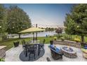 A well designed patio with a fire pit and a view of a lake offers a beautiful backyard oasis at 12770 Bristow Ln, Fishers, IN 46037