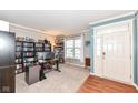Cozy living room with gray walls, white trim, and a front door leading to the home's exterior at 13685 Van Buren Pl, Fishers, IN 46038