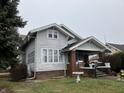 Charming two-story home featuring a covered front porch and well-maintained landscaping at 2025 Main St, Elwood, IN 46036